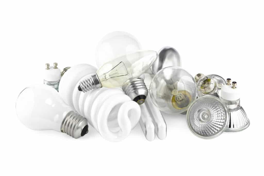 a number of different LED bulbs, filament bulbs and others placed on a white transparent surface