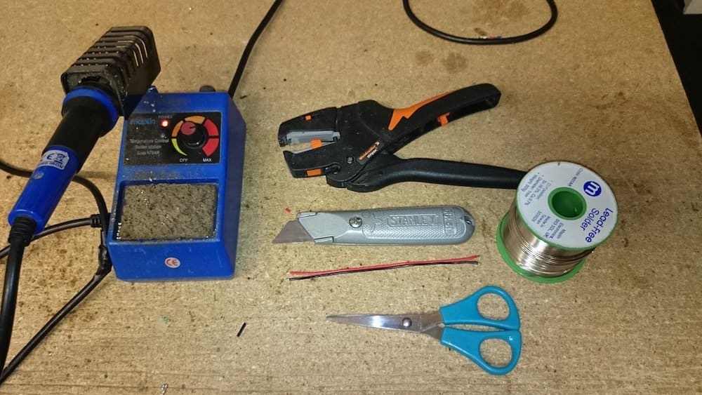 soldering device cable cutter wire scissor and a regular cutter placed on a surface