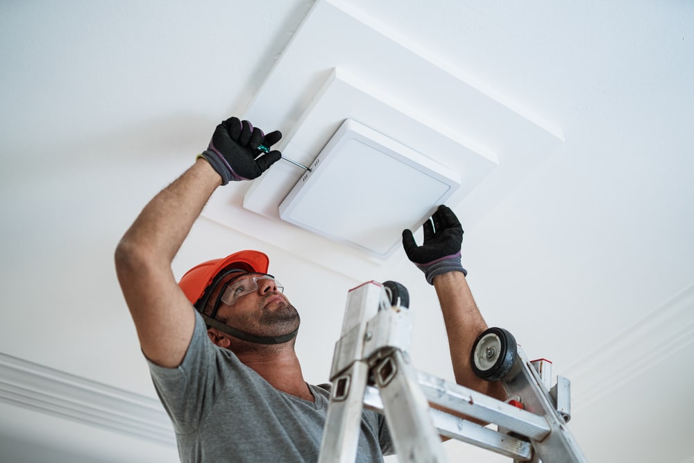 Latino Electrician Installing A Led Light On The Ceiling