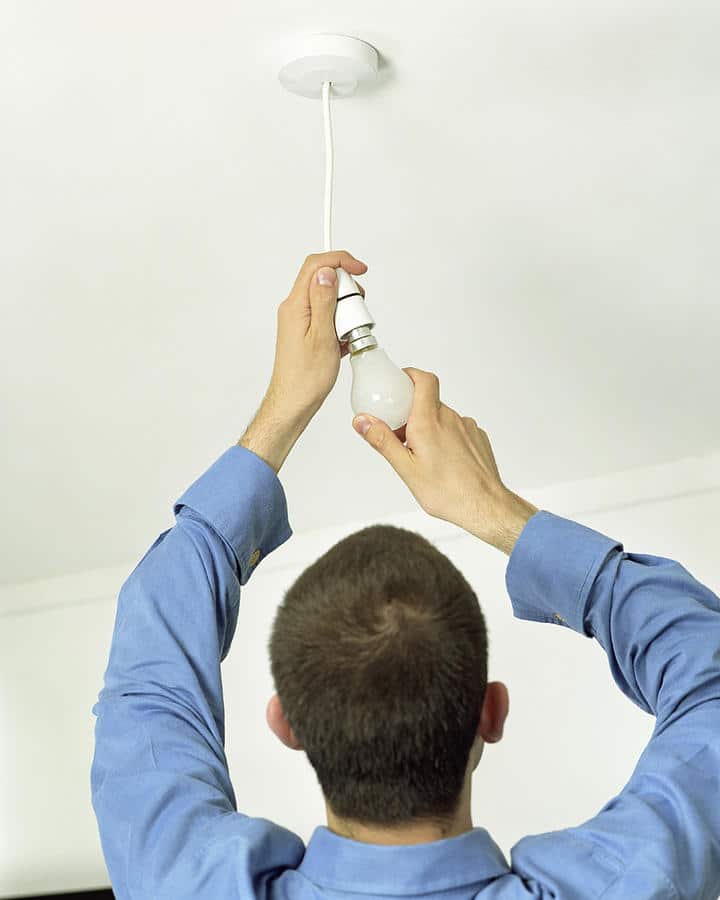 person is changing the light bulb