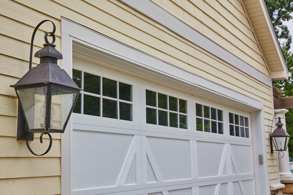 Vintage Lantern And White Garage On Yellow House Facade